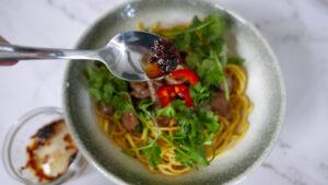 Adding chilli oil sauce to beef noodles - Cook Simply
