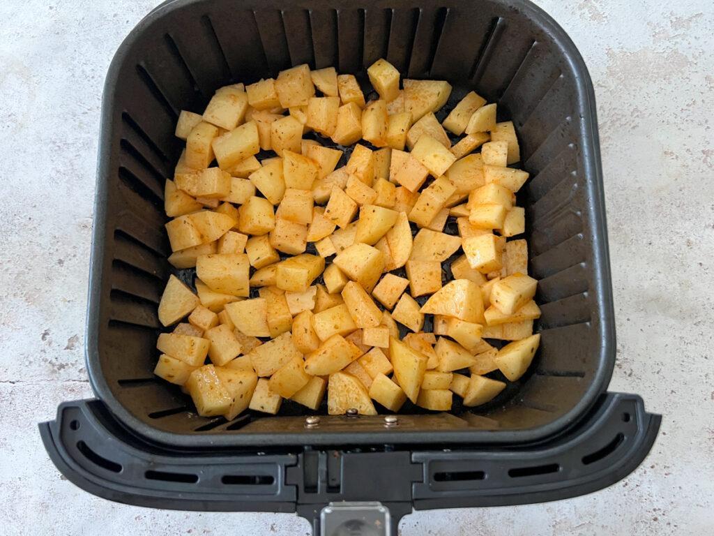 Adding diced potatoes to air fryer basket - Cook Simply