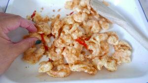 Coating crispy prawns in the seasoning - Cook Simply